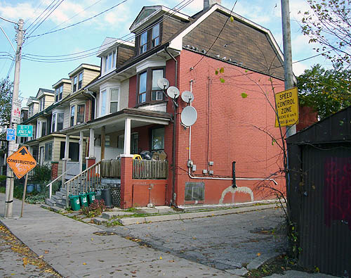 Driveway alongside row houses has small sign reading TO Nº 7 JONES AVE. &rarr;